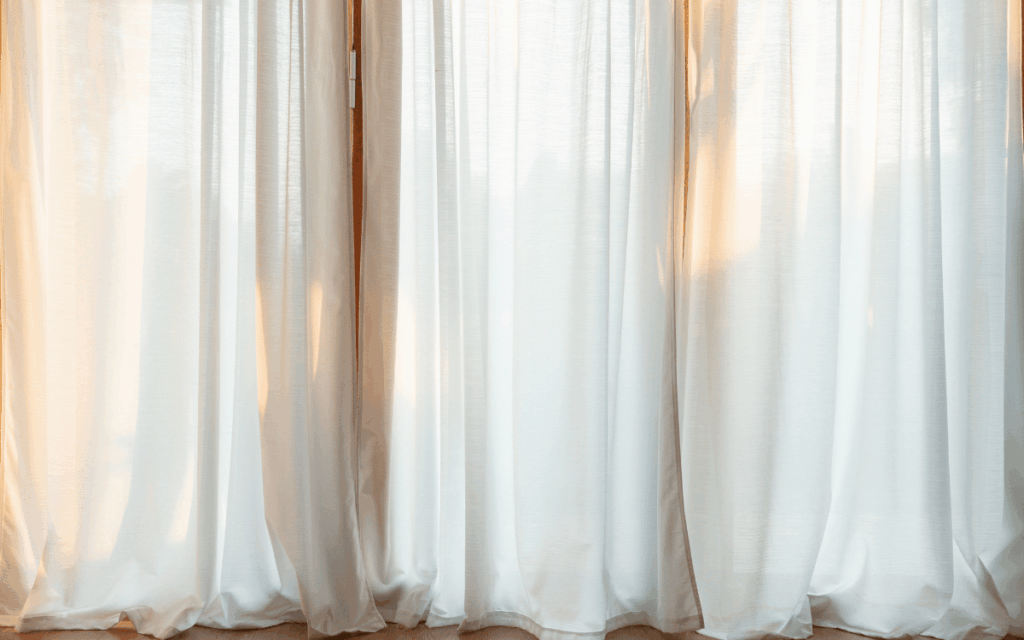 Detalle de ventana con caída perfecta de cortinas tradicionales en Sabadell hechas a medida