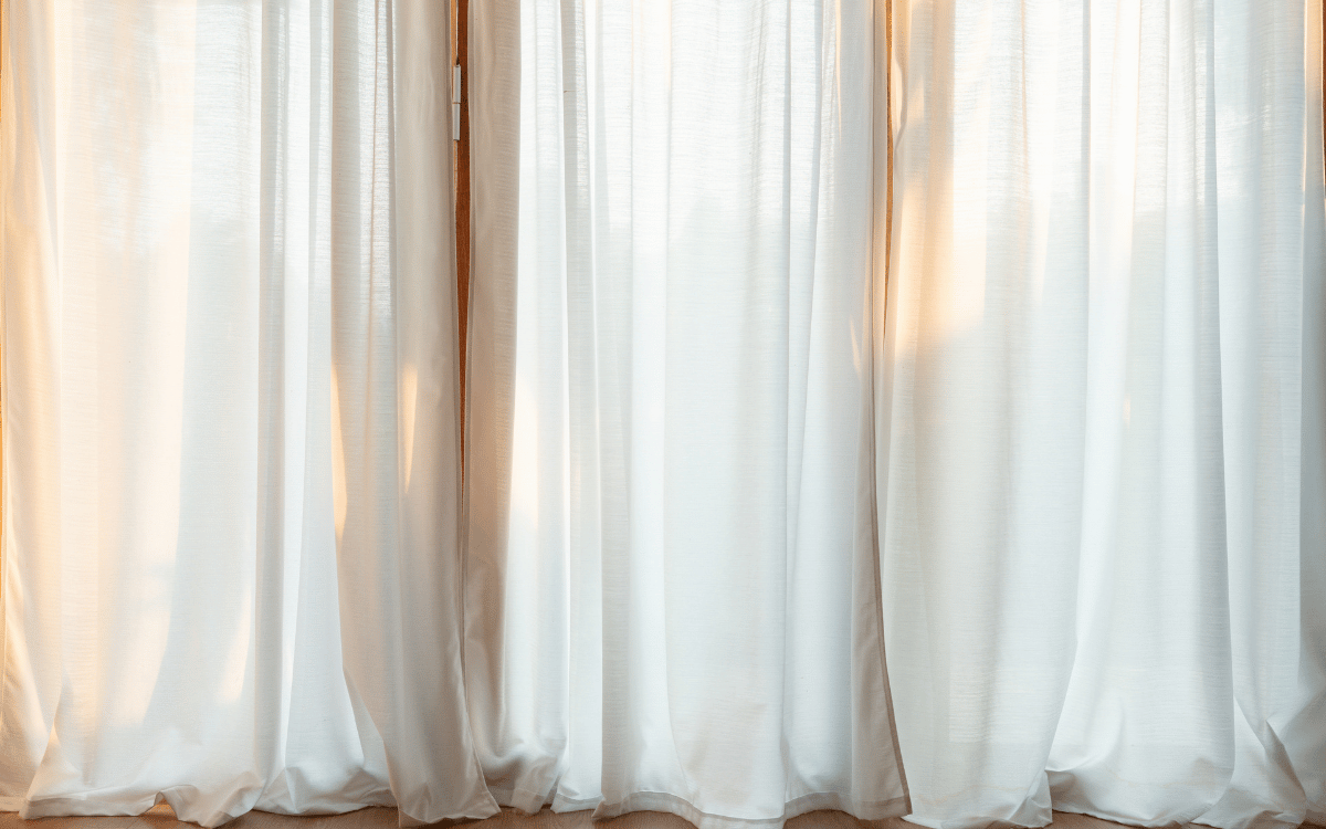 Detalle de ventana con caída perfecta de cortinas tradicionales en Sabadell hechas a medida